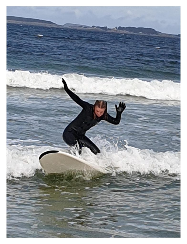 Jente surfer i blågrønt hav