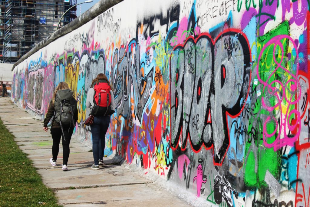 Backpackere langs graffitivegg
