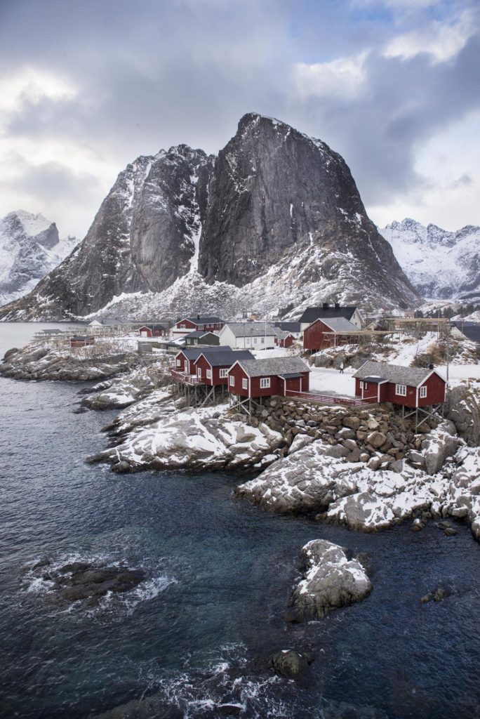 Røde rorbuer foran fjell i Hamnøy i Lofoten