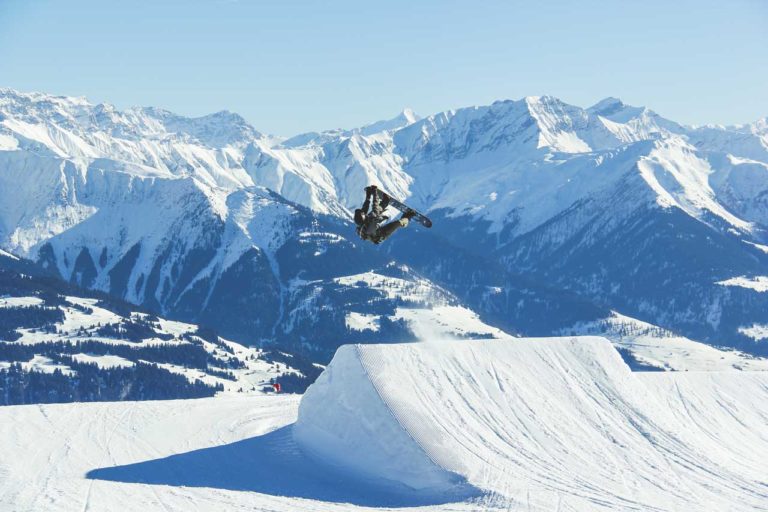 Snowboarder på hopp foran fjell