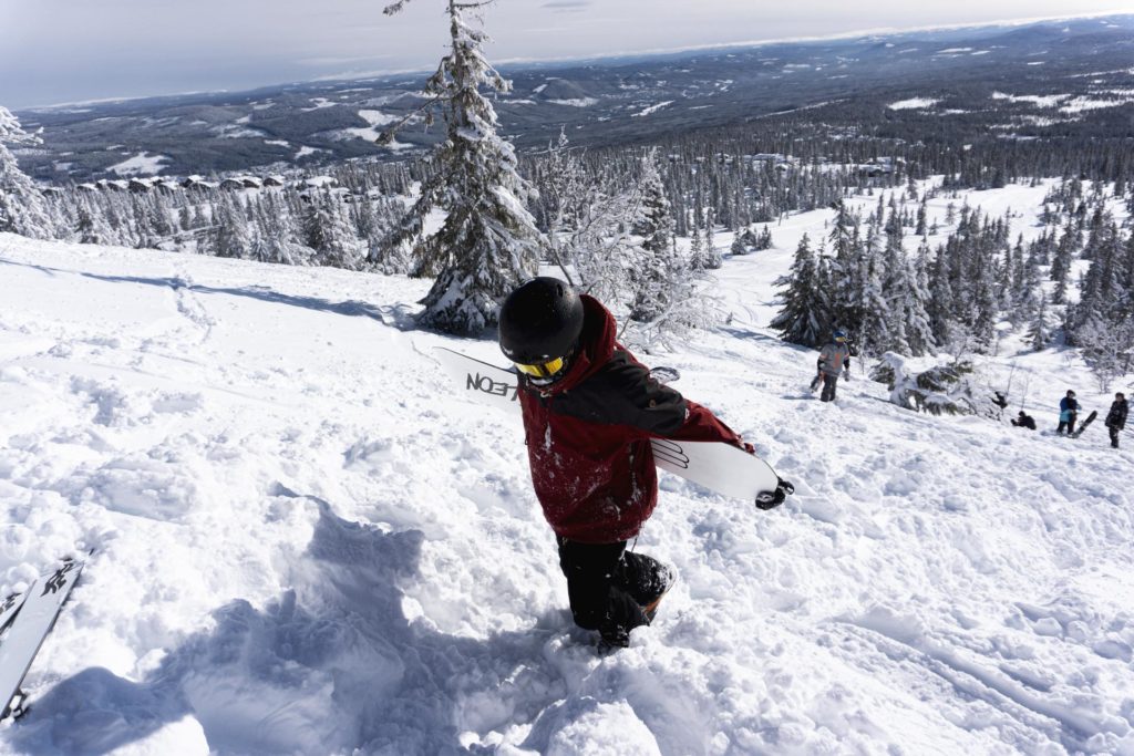 Snowboarder går oppover bakke