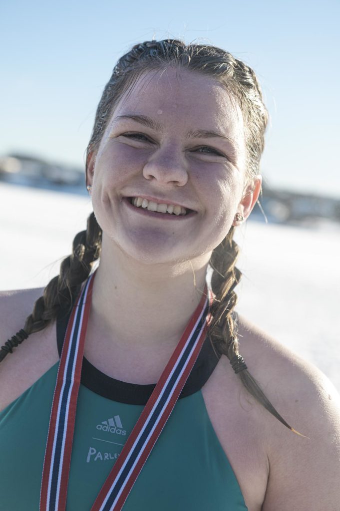 Ung kvinne smiler med medalje