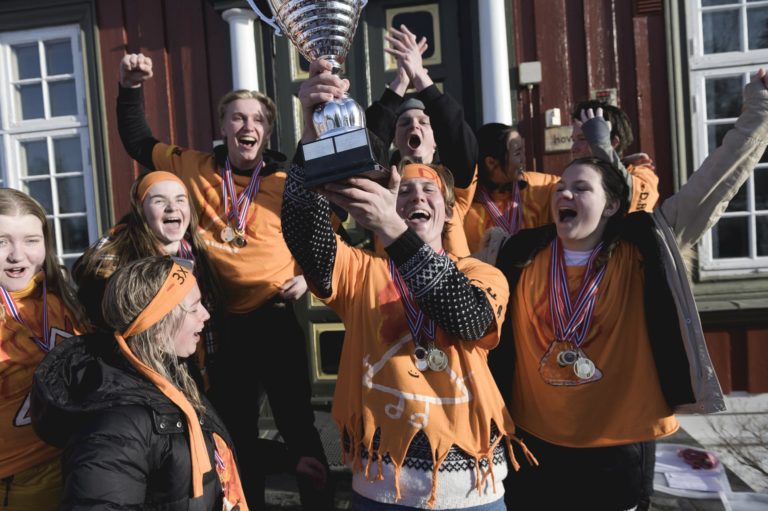 Gruppe jubler og holder pokal