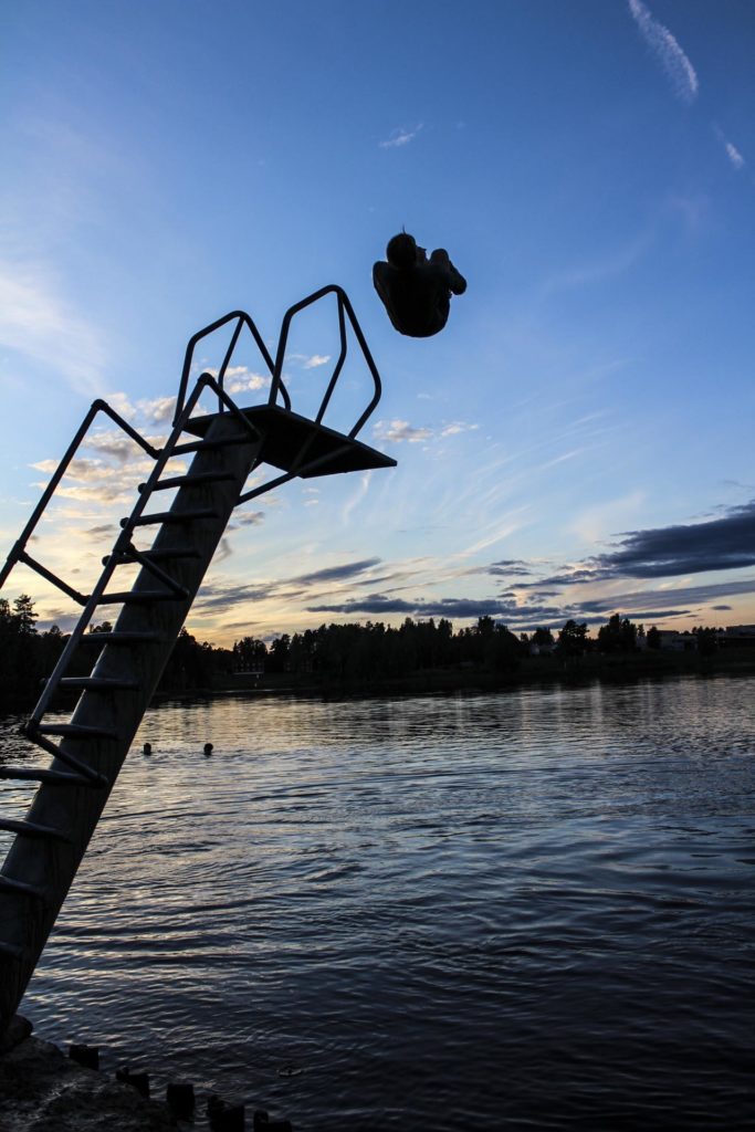 Silhuett av person som tar salto fra stupetårn