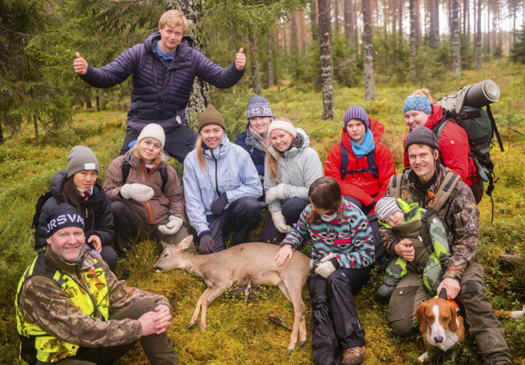 Gruppe jegere poserer med felt rådyr