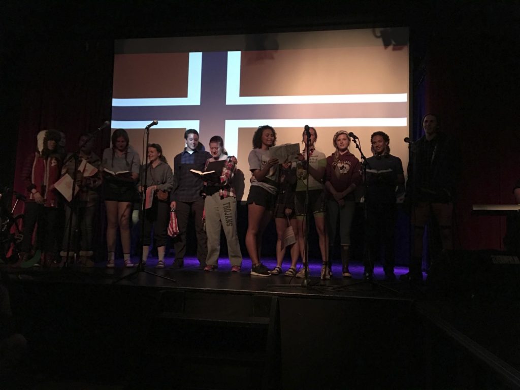 Unge mennesker på scene foran norsk flagg