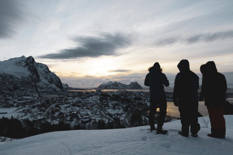 Tre silhuetter på fjelltopp over Svolvær
