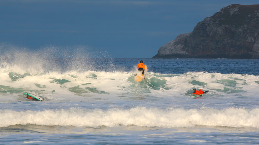 Surfer padler ut i bølger