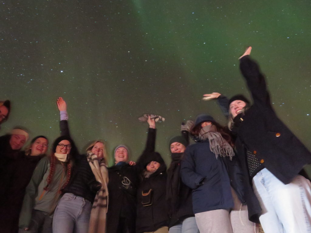 Gruppe unge mennesker under nordlys