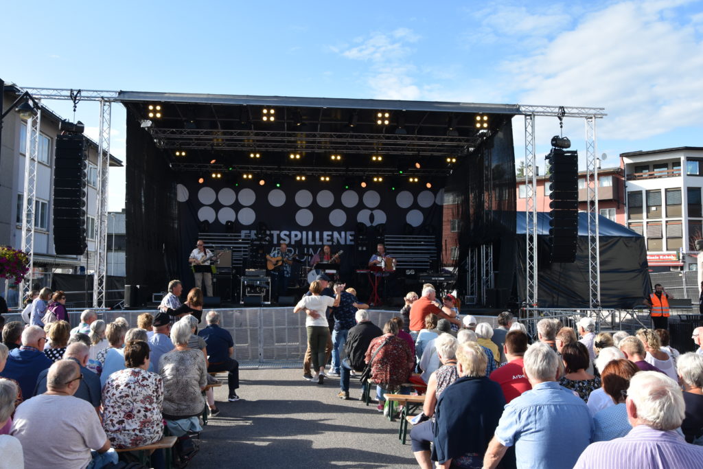 Scene med konsert og publikum på benker